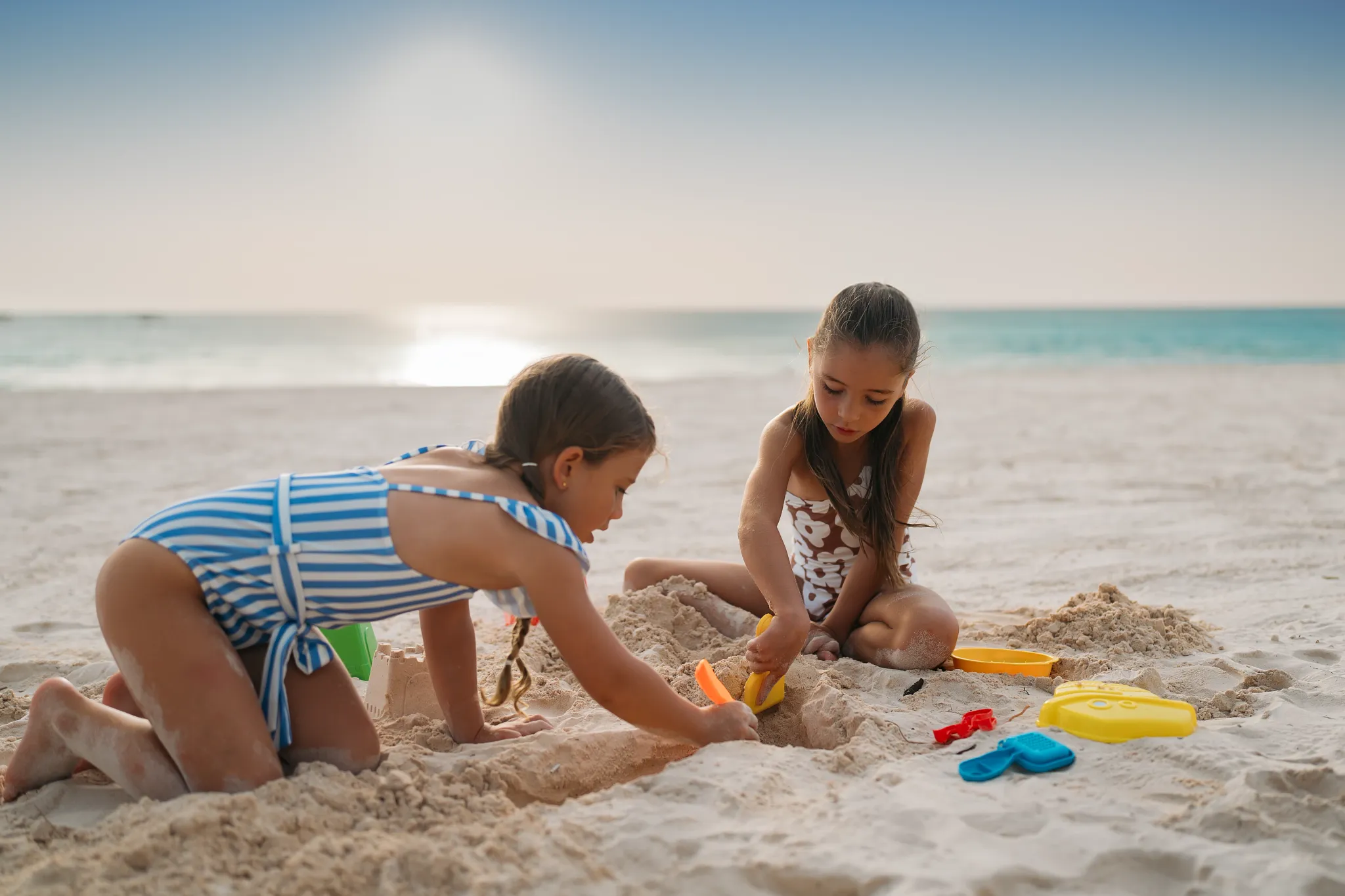 Children playing and building sandcastles on the beach at Dreams Royal Beach Punta Cana, perfect for family vacations in Punta Cana.