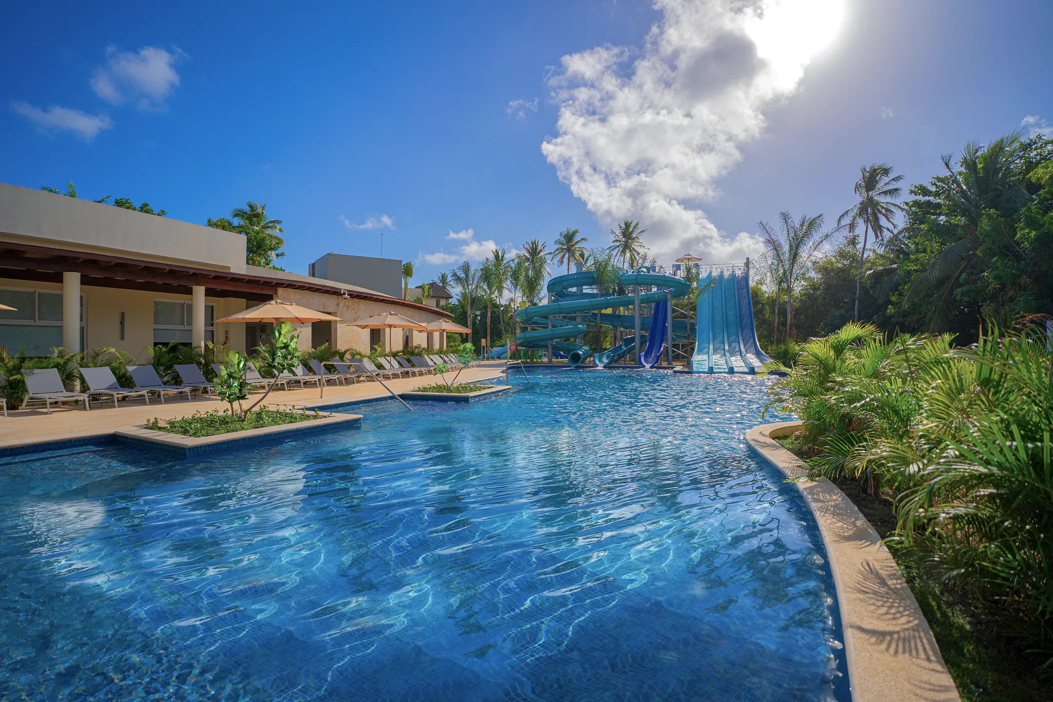 Large resort pool with water slides and sun loungers at Dreams Royal Beach Punta Cana.