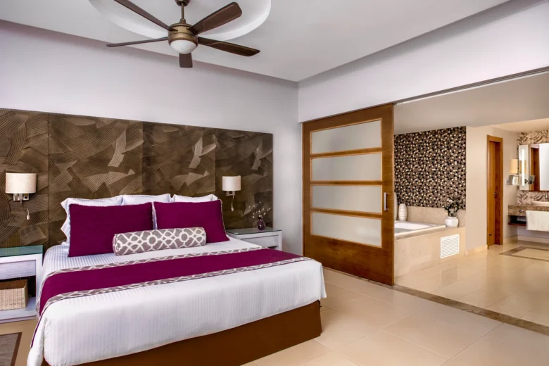 King bedroom with modern decor and sliding doors to bathroom suite.